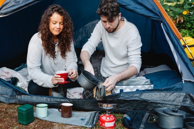 Jong stel voor de tent die aan het koken zijn op gas