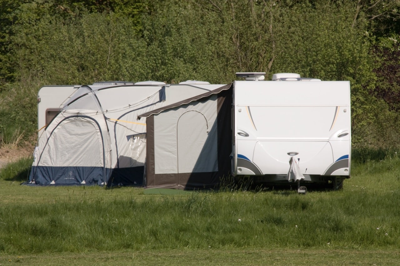camper en tent op een grasveld